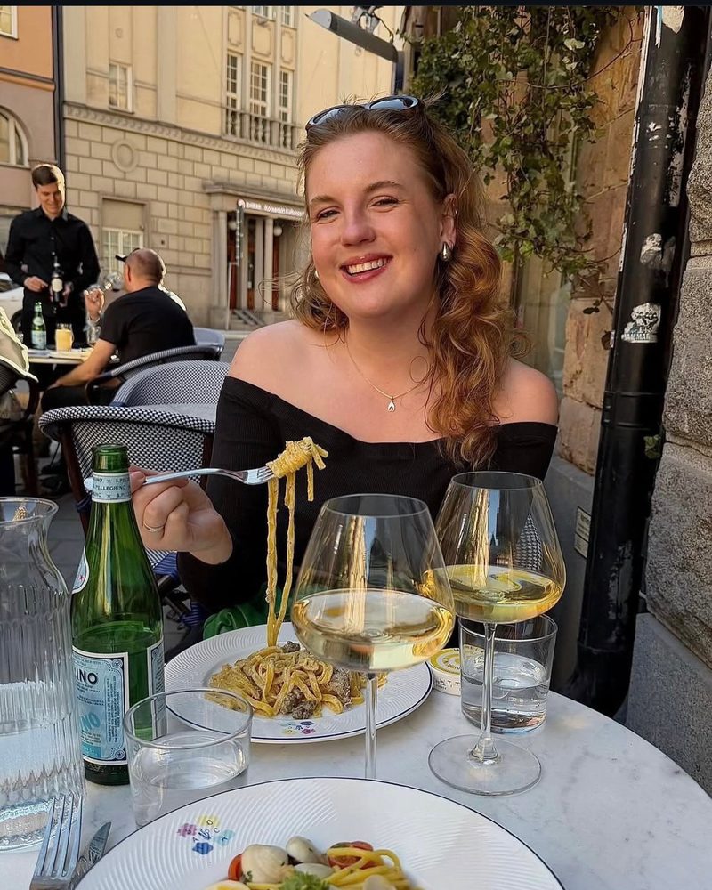 Julia Hellgreen smiling at an outdoor restaurant table in Stockholm